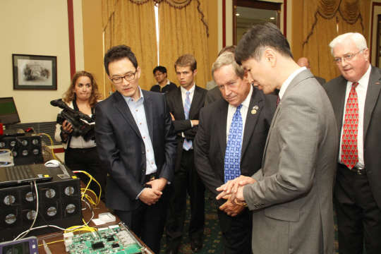 SK텔레콤(대표 장동현)은 8일(현지시간) 미국 워싱턴D.C. 국회의사당 의원회관에서 국회의원과 정부기관 관계자, 언론을 대상으로 차세대 통신보안기술인 '양자암호통신' 시스템을 전시하고 도 감청 실시간 탐지 등 핵심기능을 시연했다. 이날 시연회에 참석한 조 윌슨 미 의회 군사위원회 소속 의원(공화당·앞줄 왼쪽 두번째)이 양자암호통신 시스템에 대한 설명을 듣고 있다.  SK텔레콤 제공